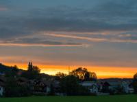 Der Horizont und einzelne Wolkenstreifen glühen im letzten Sonnenlicht